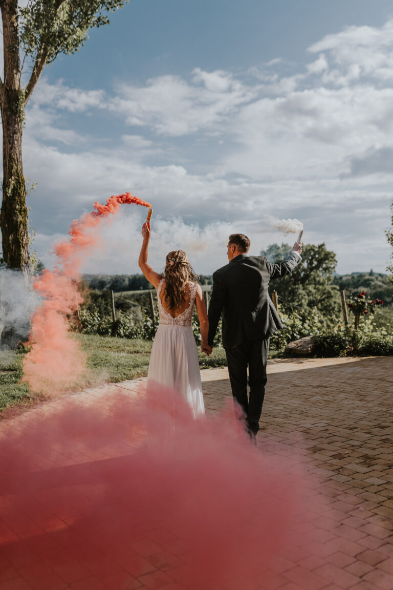 Brautpaar spaziert mit Rauchfackeln in den Händen