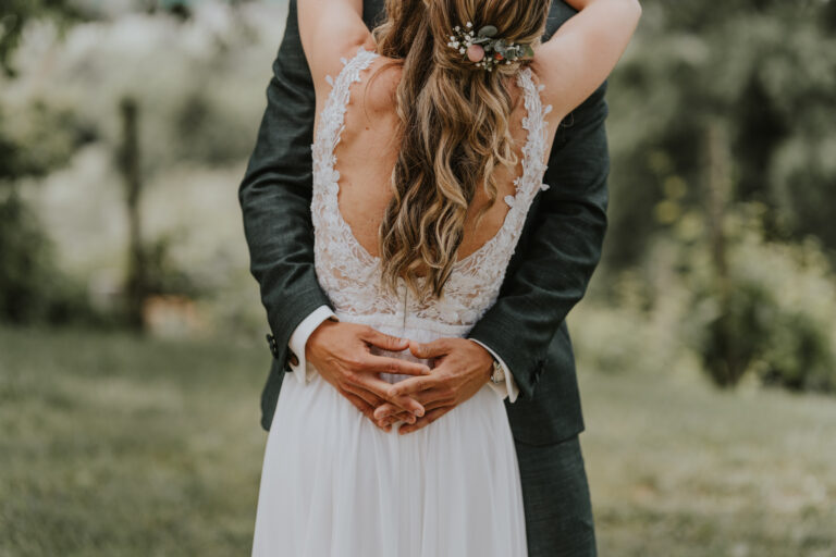Hände des Bräutigams umarmen die Braut