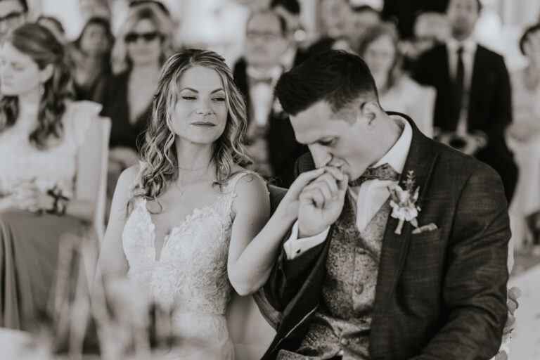 Bräutigam küsst die Hand seiner Braut bei der Trauung