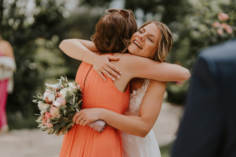 Braut umarmt einen Hochzeitsgast