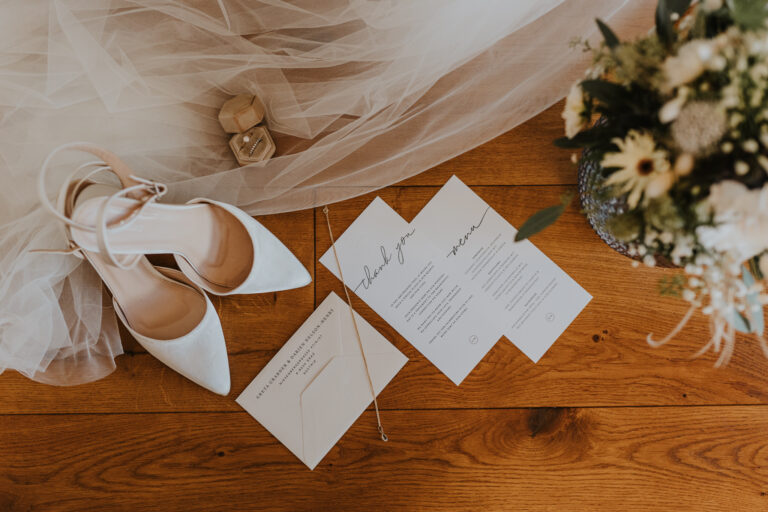 Brautschuhe und Einladungen mit Schmuck