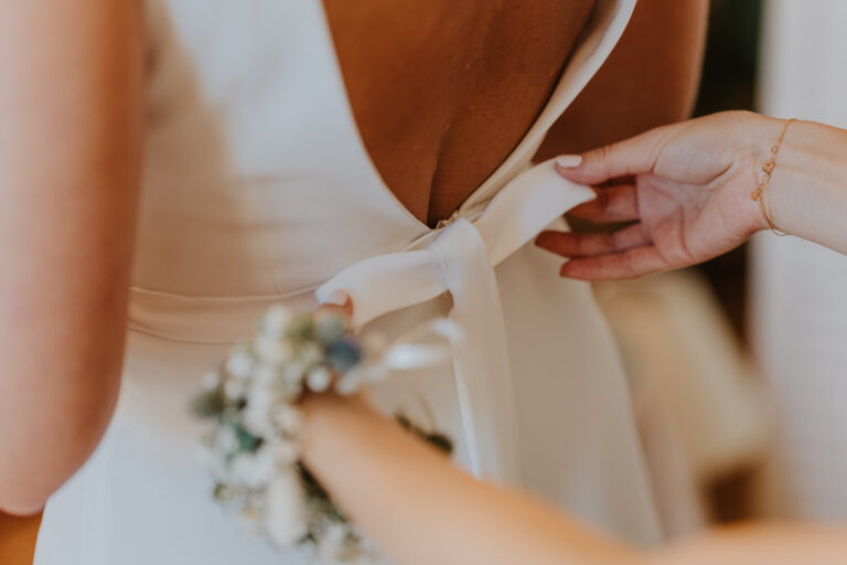 Braut zieht ihr Brautkleid an