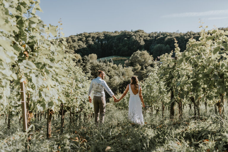 Brautpaar spaziert durch die steirischen Weinreben