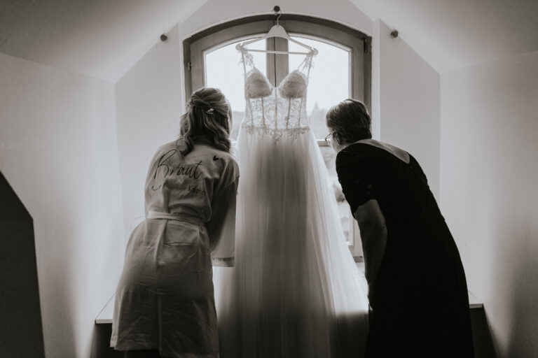 Braut und Trauzeugen spähen aus dem Fenster