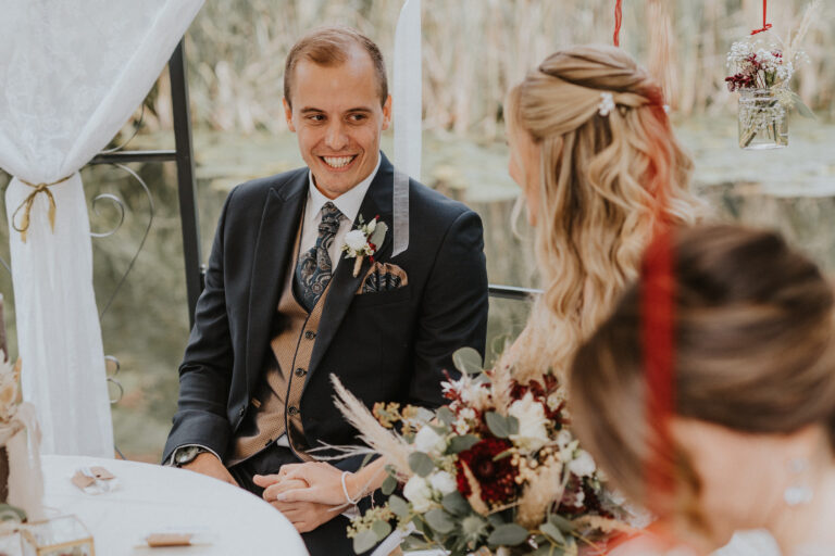 Der Bräutigam lächelt seine Braut an
