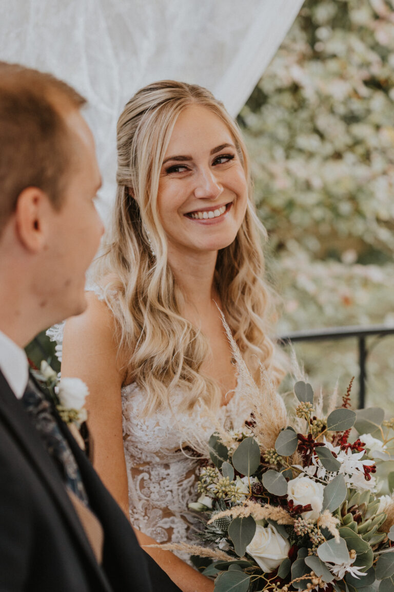 Die Braut lächelt den Bräutigam an