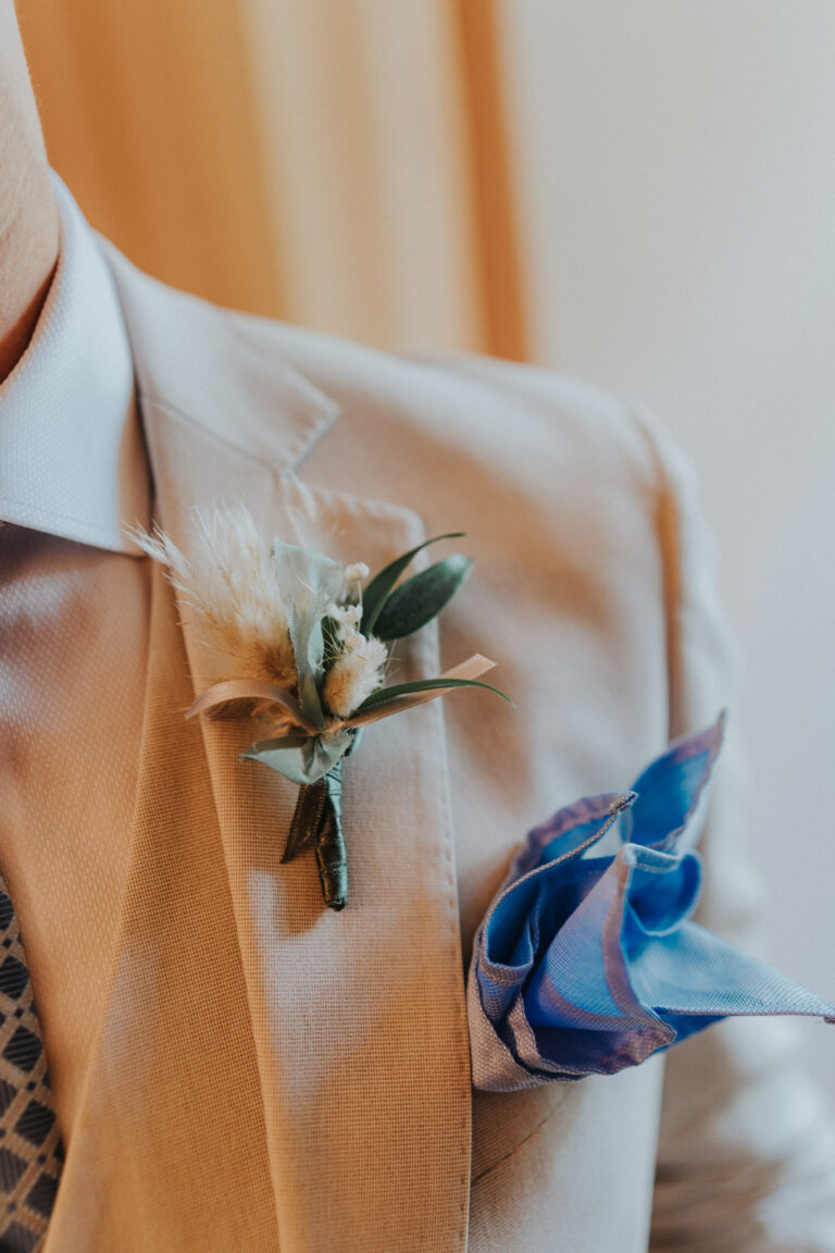 Der Blumenschmuck am Anzug des Bräutigams